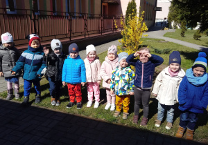 Dzieci stoją przed przedszkolem